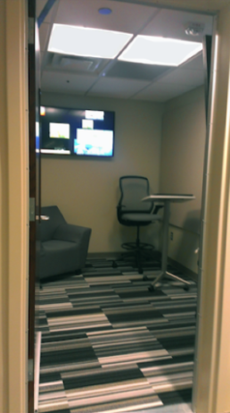 The Sound Studio in room 121. This studio features a small table with a rolling chair, a larger cushioned chair, and a television display